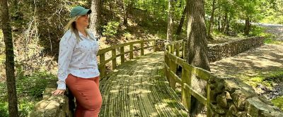 Chelsea McCurdy strands on a scenic bridge looking into the distance. 